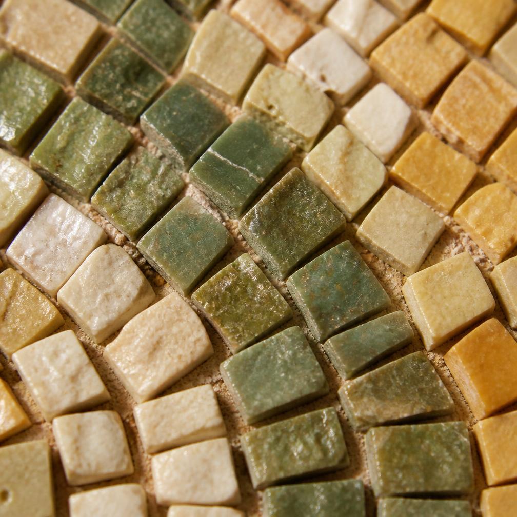 Detail of individual mosaic tesserae in olive, cream and ochre
