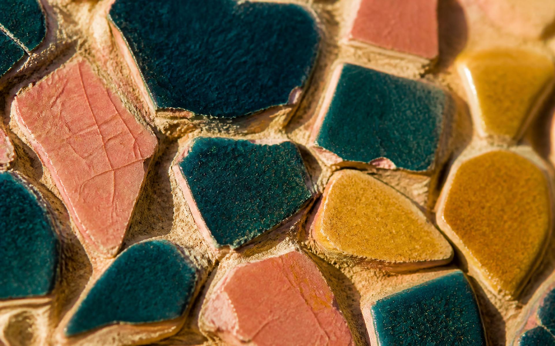 Macro detail of hand-cut teal, pink and ochre tesserae